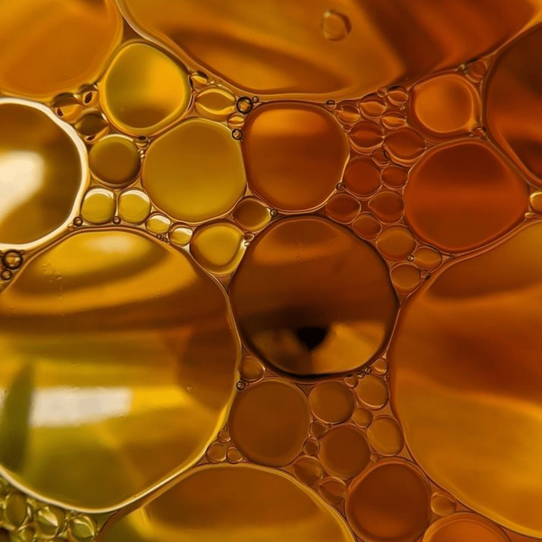 Close-up of golden oil and water bubbles in abstract form.
