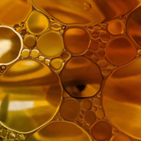 Close-up of golden oil and water bubbles in abstract form.