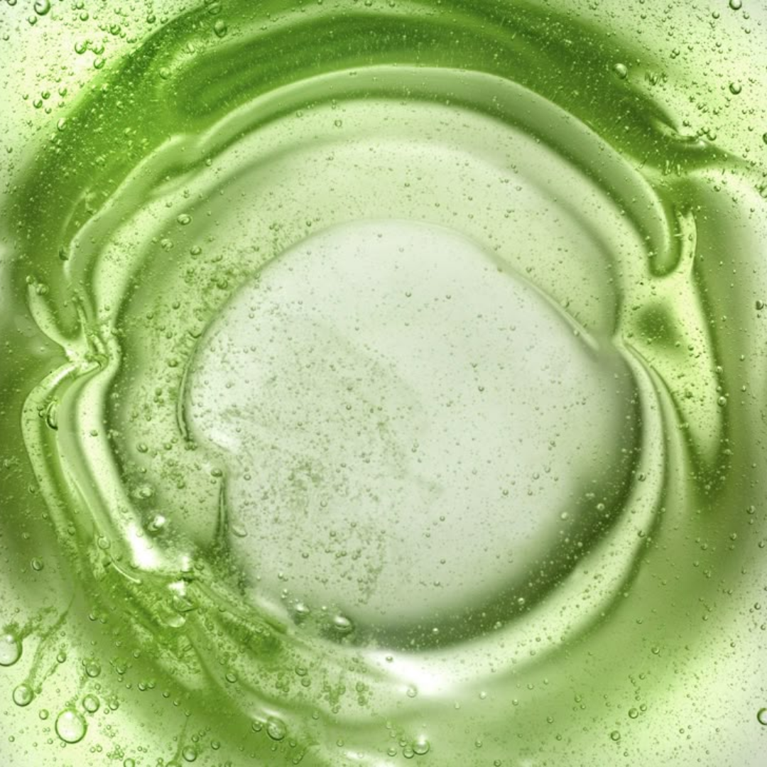 A stream of aloe vera is being poured into a transparent glass.