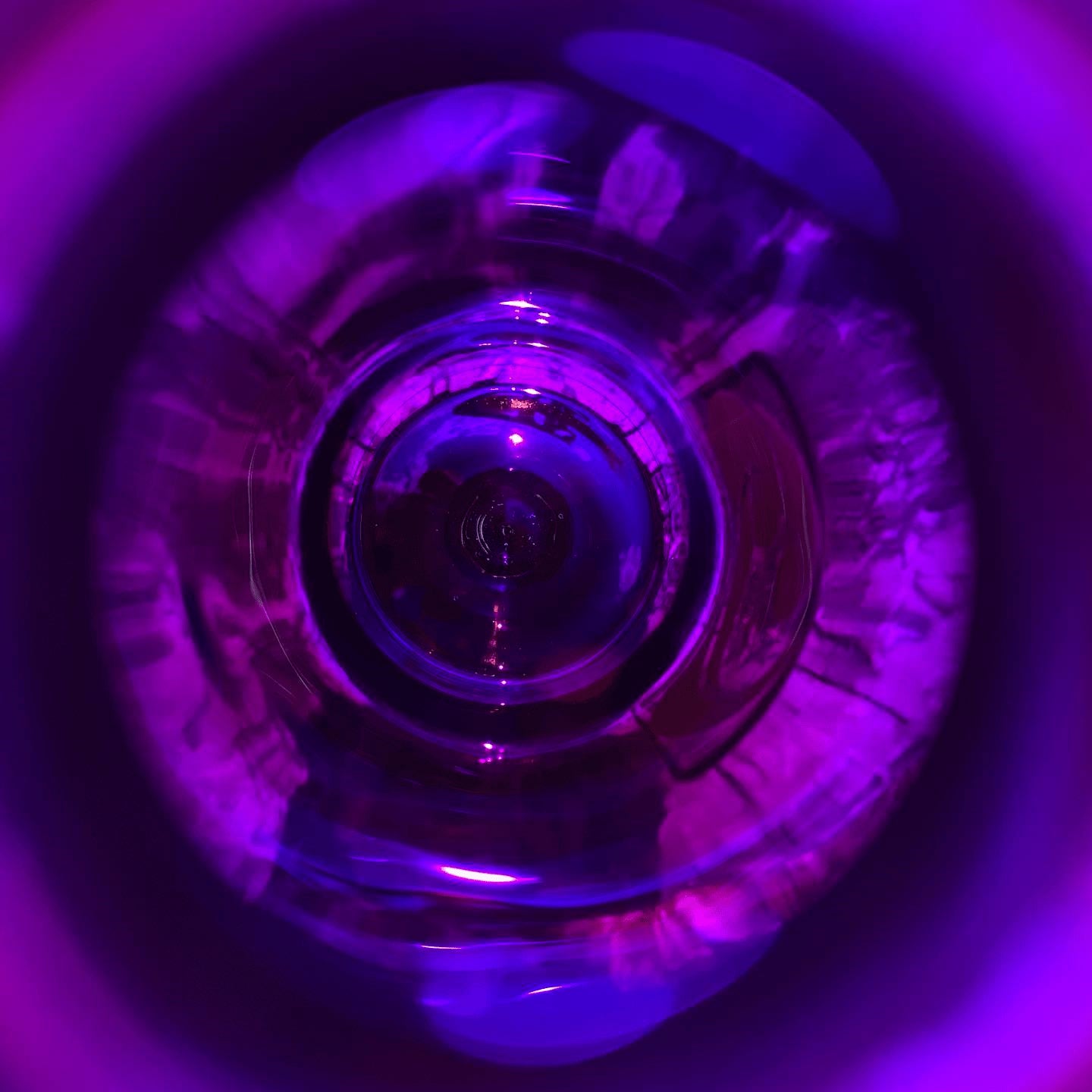A glass containing a purple light, illuminating the interior with a vibrant glow.