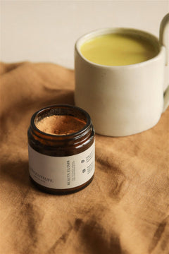 Beauty Elixir powder with golden latte on fabric.