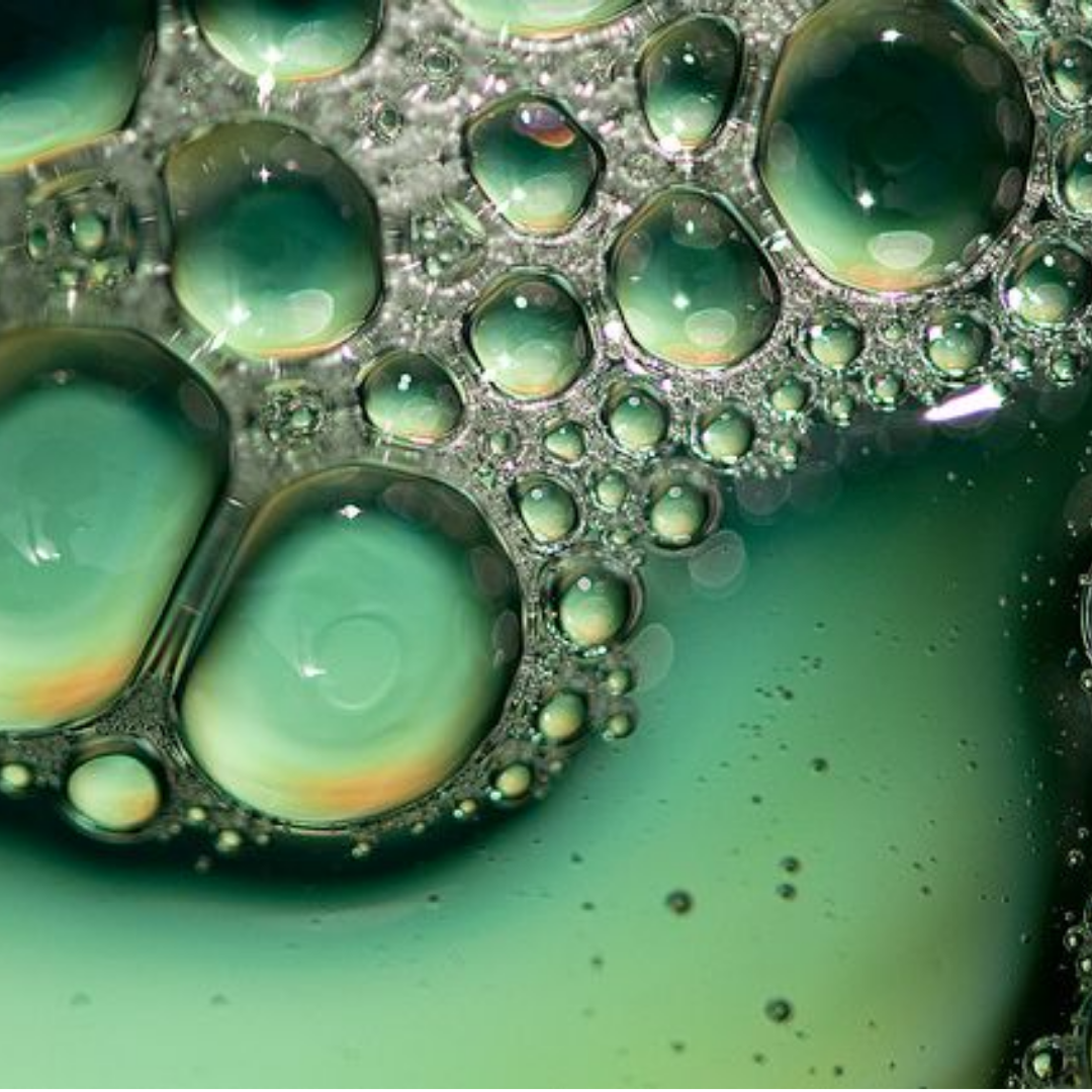 Detailed view of bubbles rising in a green liquid.