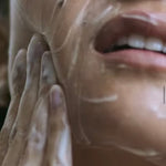 A woman, cleaning her face using the product.