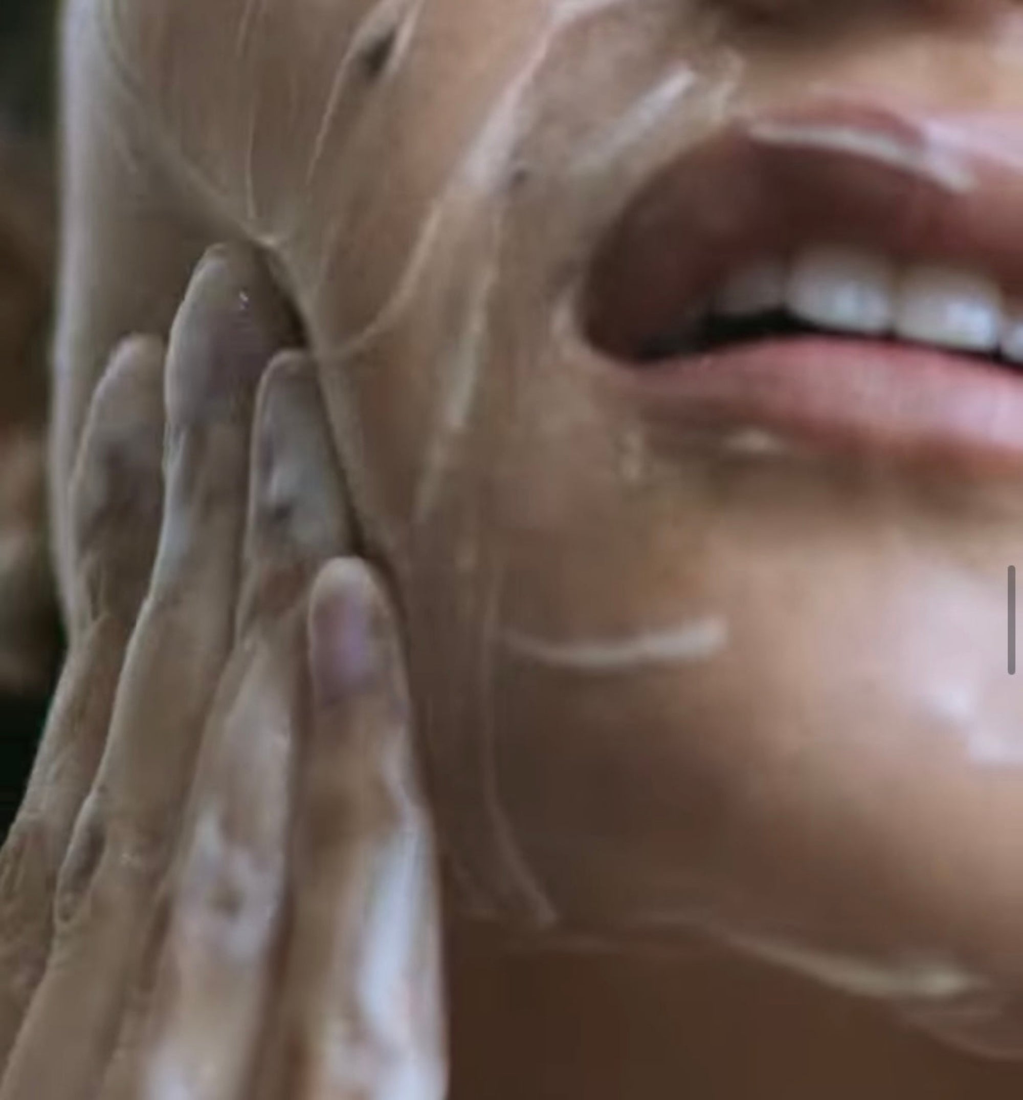 A woman, cleaning her face using the product.