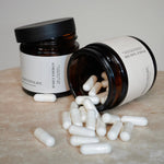 Two jars filled with NMN capsules are placed on a wooden table.