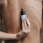 A person holding the perfect skin product on the back.