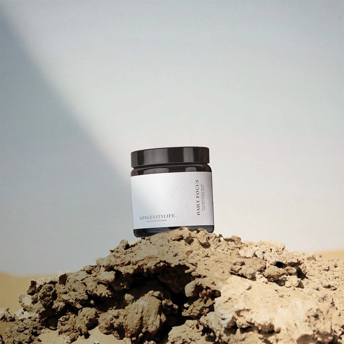 A jar containing capsules to sharpen focus, on top of the rock.