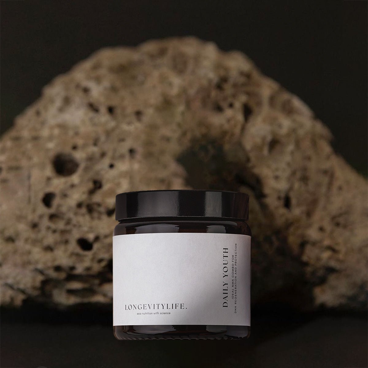 Daily youth NMN jar with rock behind.