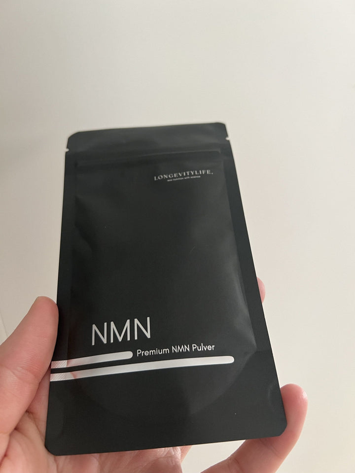 Hand hält Premium NMN Pulver von LongevityLife für die Morgenroutine