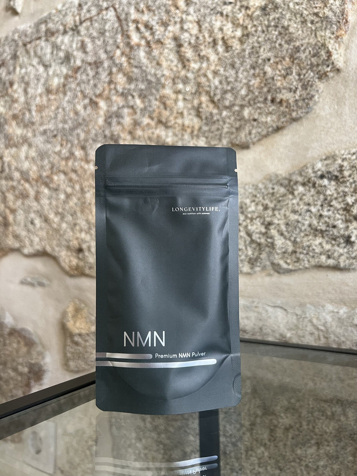 Premium NMN Pulver von LongevityLife vor einer Natursteinwand