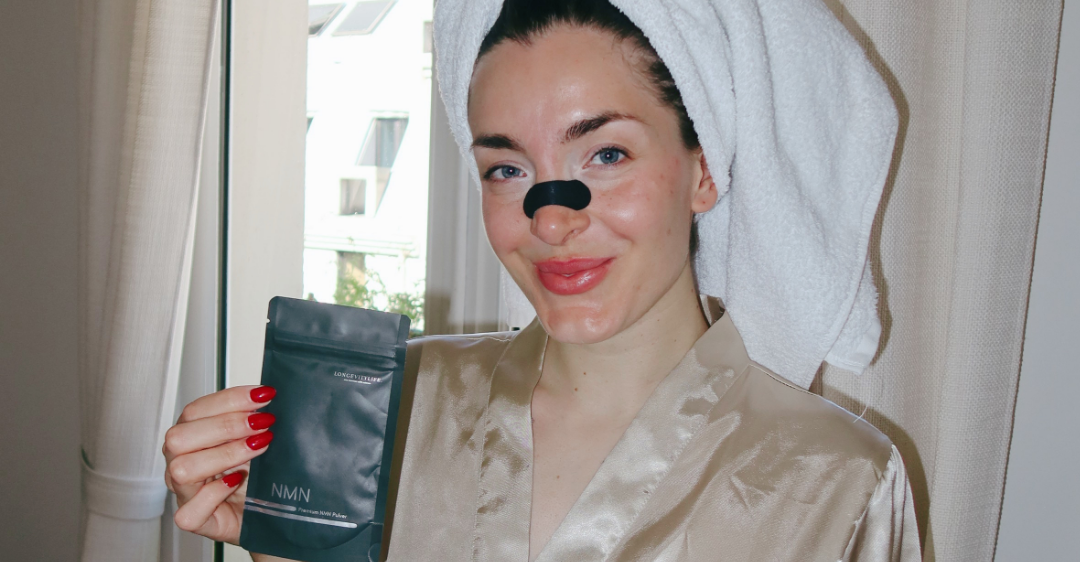 Miriam Janke mit Handtuch, Nasenstrip und NMN Beutel am Fenster
