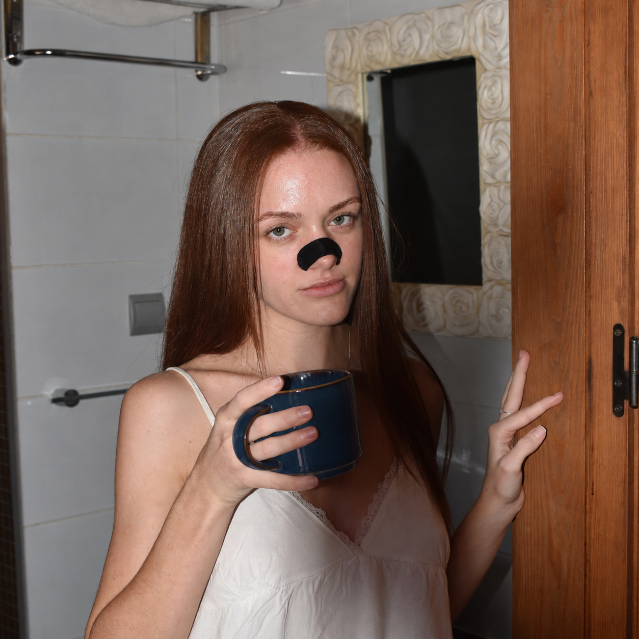 Frau mit Silk-Nasenpflaster und blauer Tasse im Bad