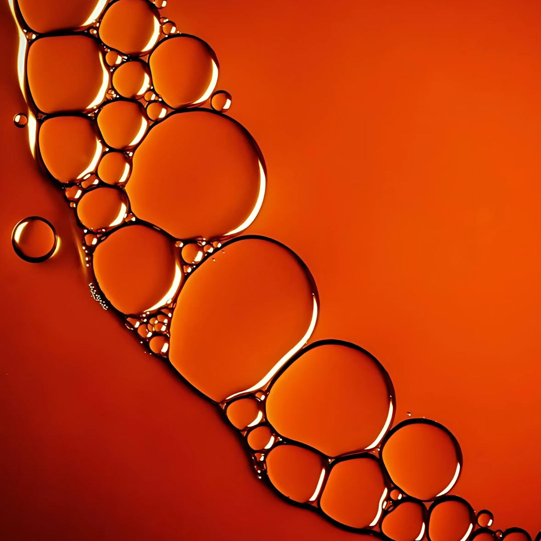 A collection of oil bubbles rests on a bold red background.