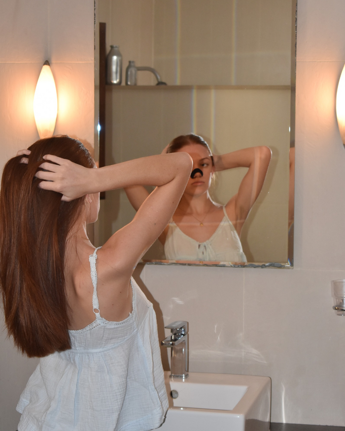 Frau mit Silk-Nasenpflaster vor dem Badezimmerspiegel