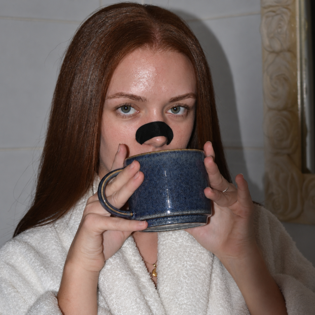 Frau mit Silk-Nasenpflaster trinkt aus einer blauen Tasse