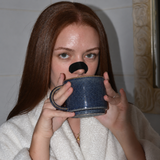 Frau mit Silk-Nasenpflaster trinkt aus einer blauen Tasse
