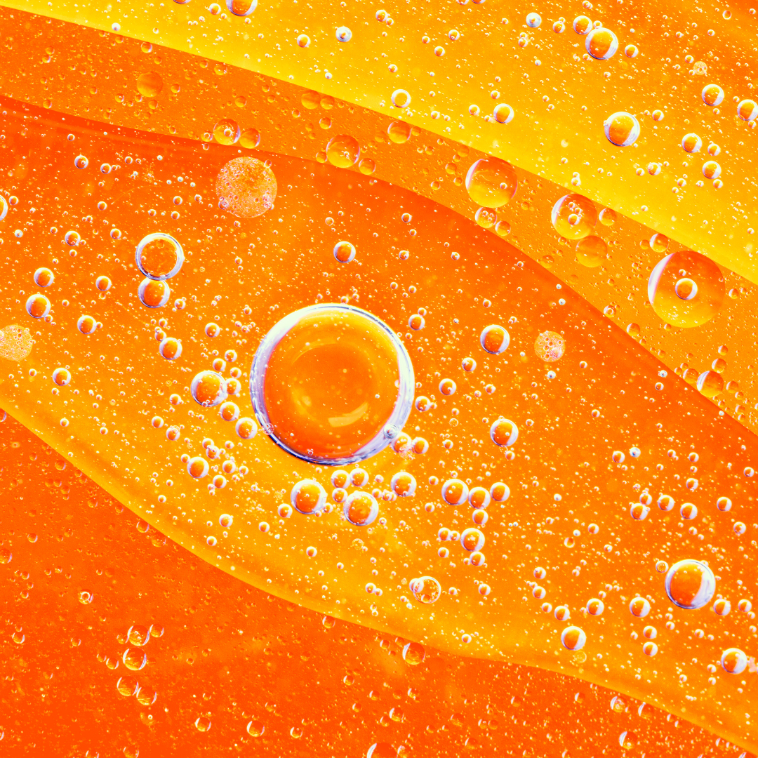 Water droplets on a surface with orange and yellow colors.