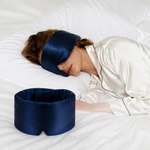 Frau schläft mit Satin-Schlafmaske in Night Blue, daneben eine zweite Maske
